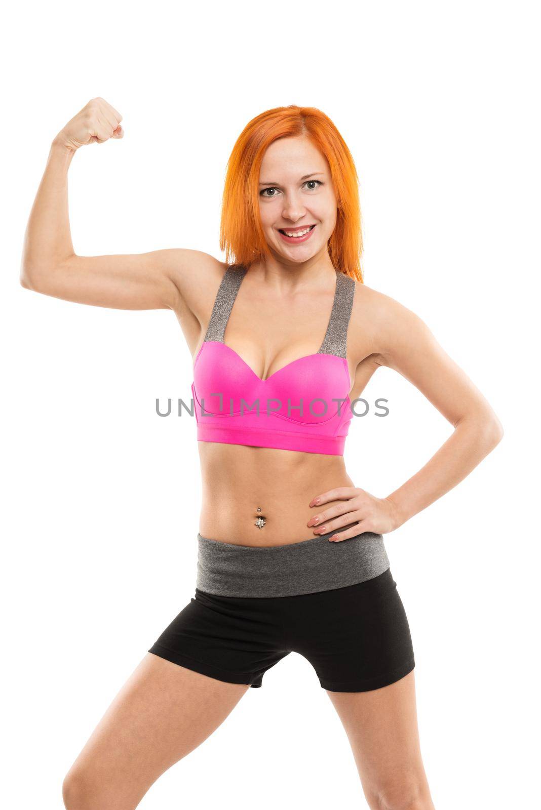 Young slim sensual red woman wearing sports bra practicing fitness