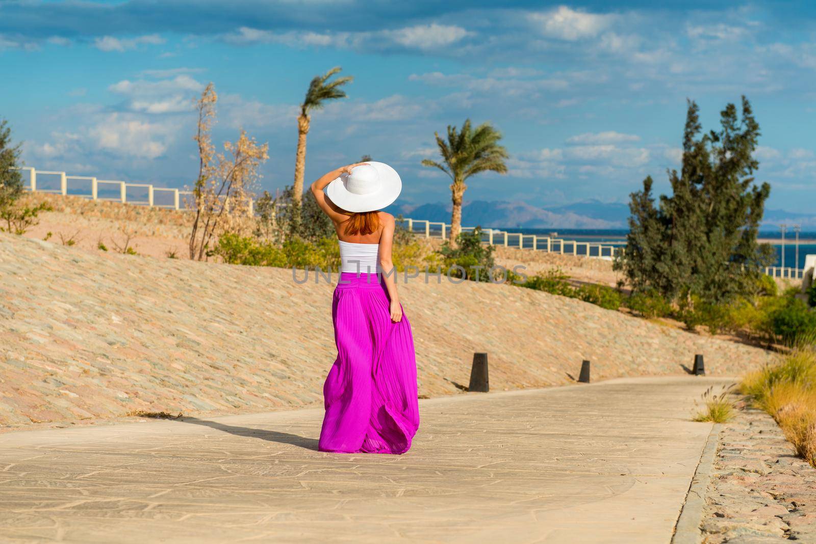 Photo of beautiful young woman in a hat at sea resort