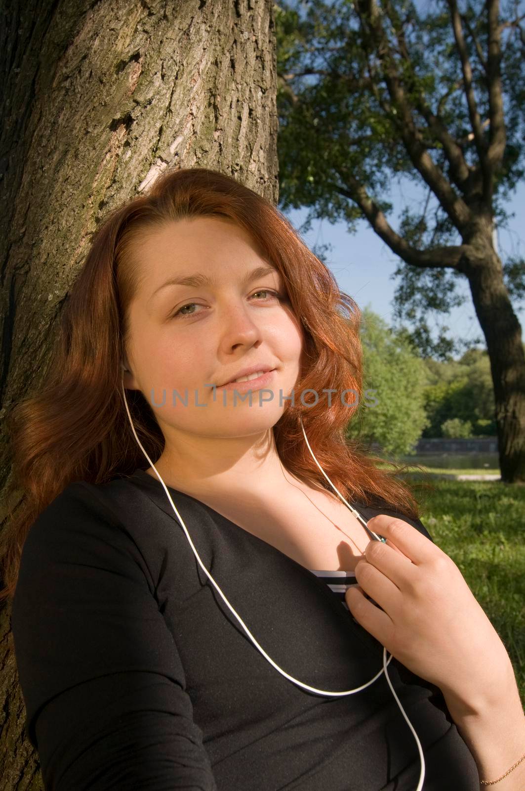 Girl sitting at the park listening to the music