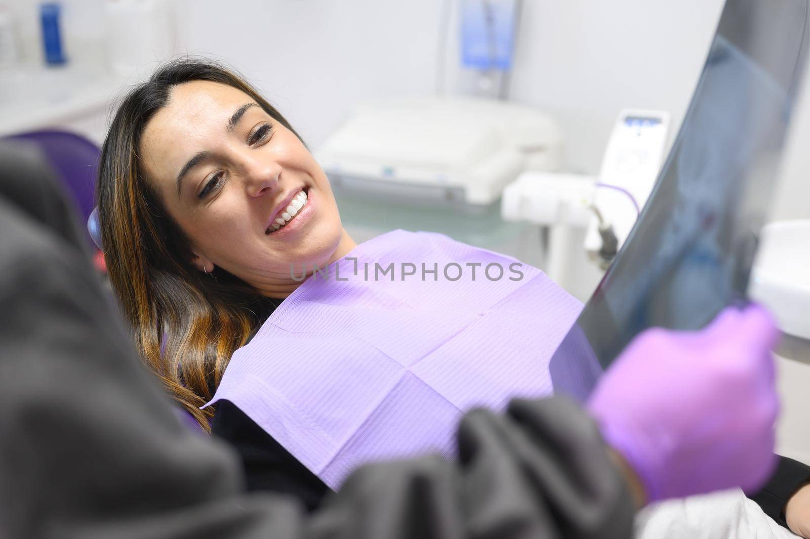 Doctor dentist showing patient's teeth on X-ray by HERRAEZ