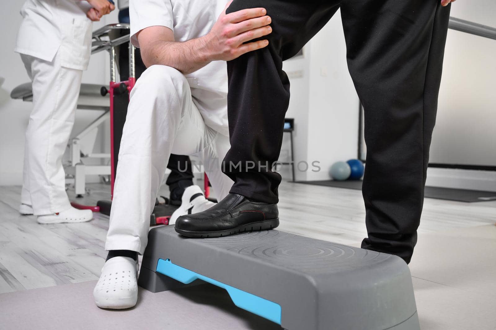 Senior Patient and physical therapist in rehabilitation walking exercises. by HERRAEZ