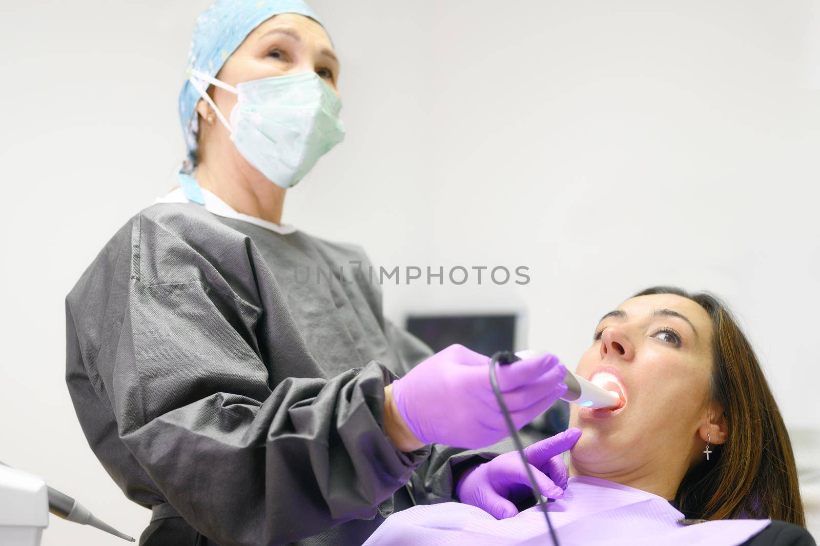 Doctor examining patient's teeth with intraoral camera. High quality photo