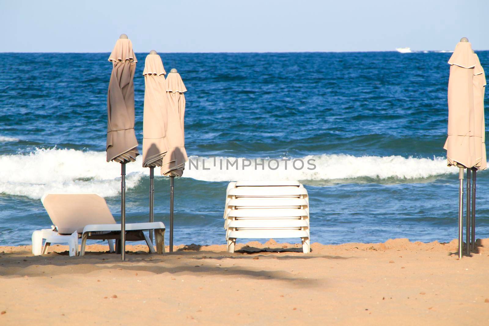 Beach umbrellas and hammocks on the beach at sunset in Summer