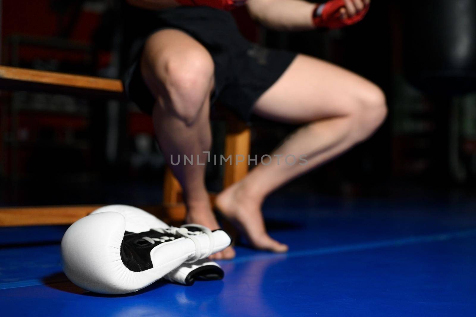 Closeup of boxer legs resting on bench in gym after training. High quality photo