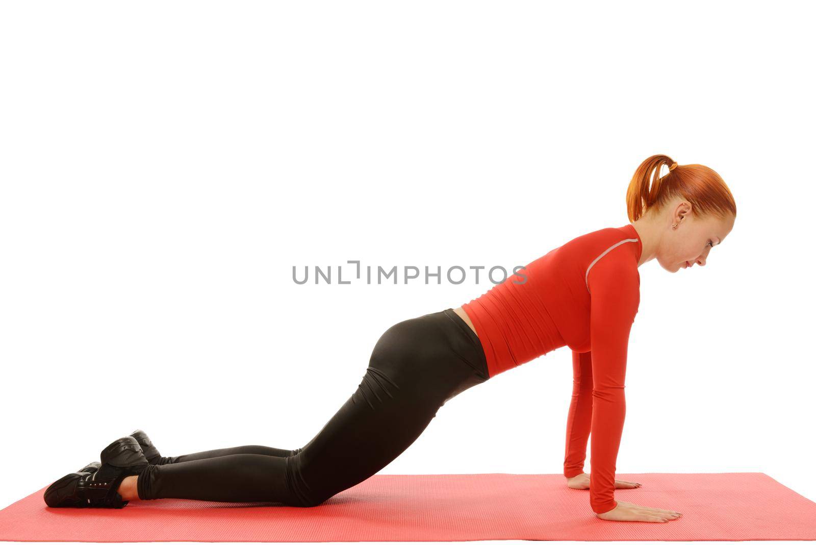Beautiful slim red fit woman doing pushups over white background