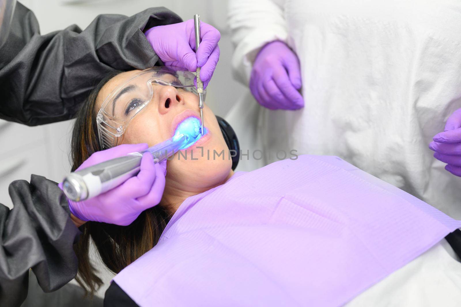 Young woman receiving ultraviolet light procedure at dentist office. High quality photo