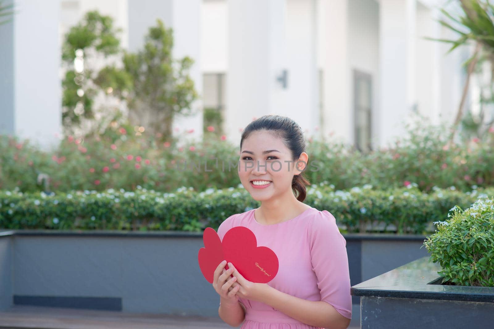 Image of happy beautiful female reading romantic postcard with big red heart, attractive woman got sensual greeting card, valentine day,love concept by makidotvn