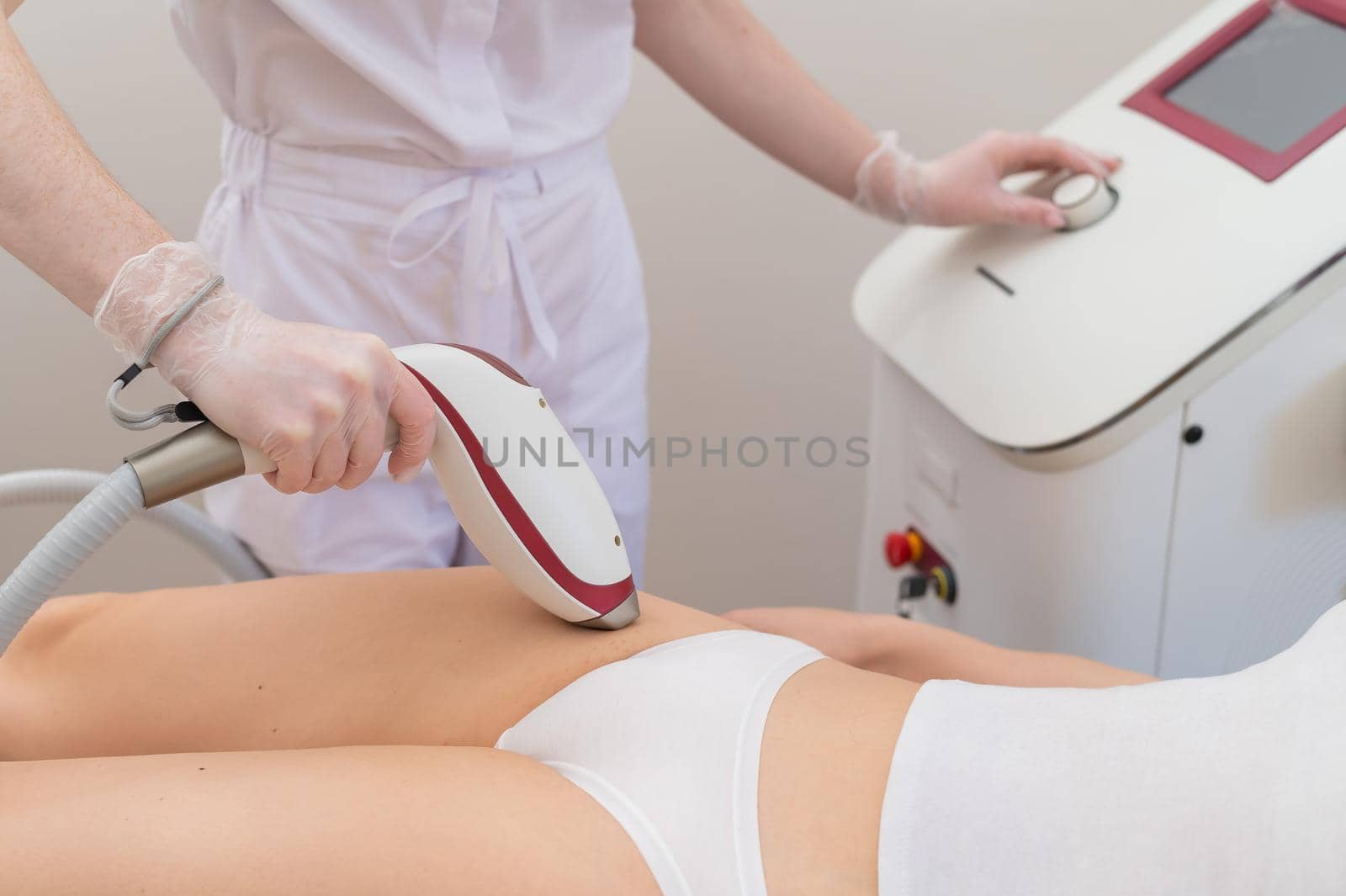 A woman in a professional beauty salon removes unwanted vegetation in the bikini area using laser hair removal.