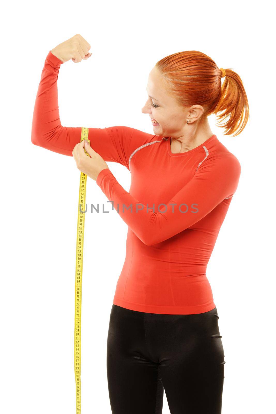 Beautiful slim red fit woman holding measuring tape to her bicep over white background
