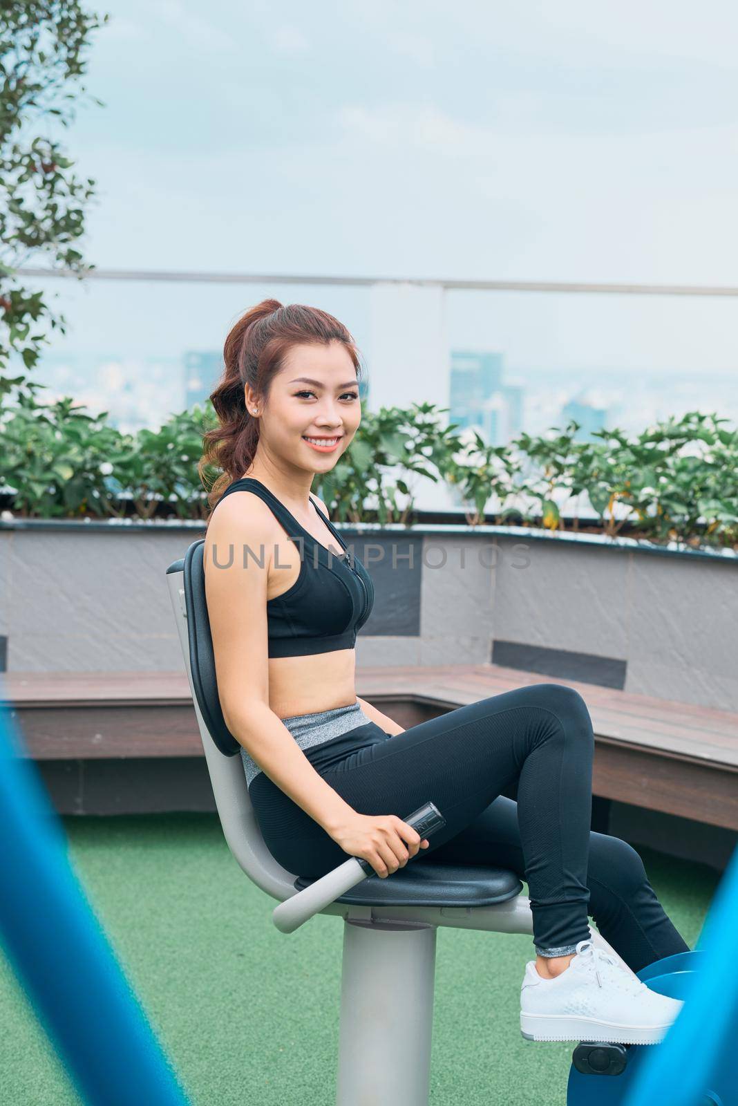 Asian woman exercising at outdoors gym playground equipment