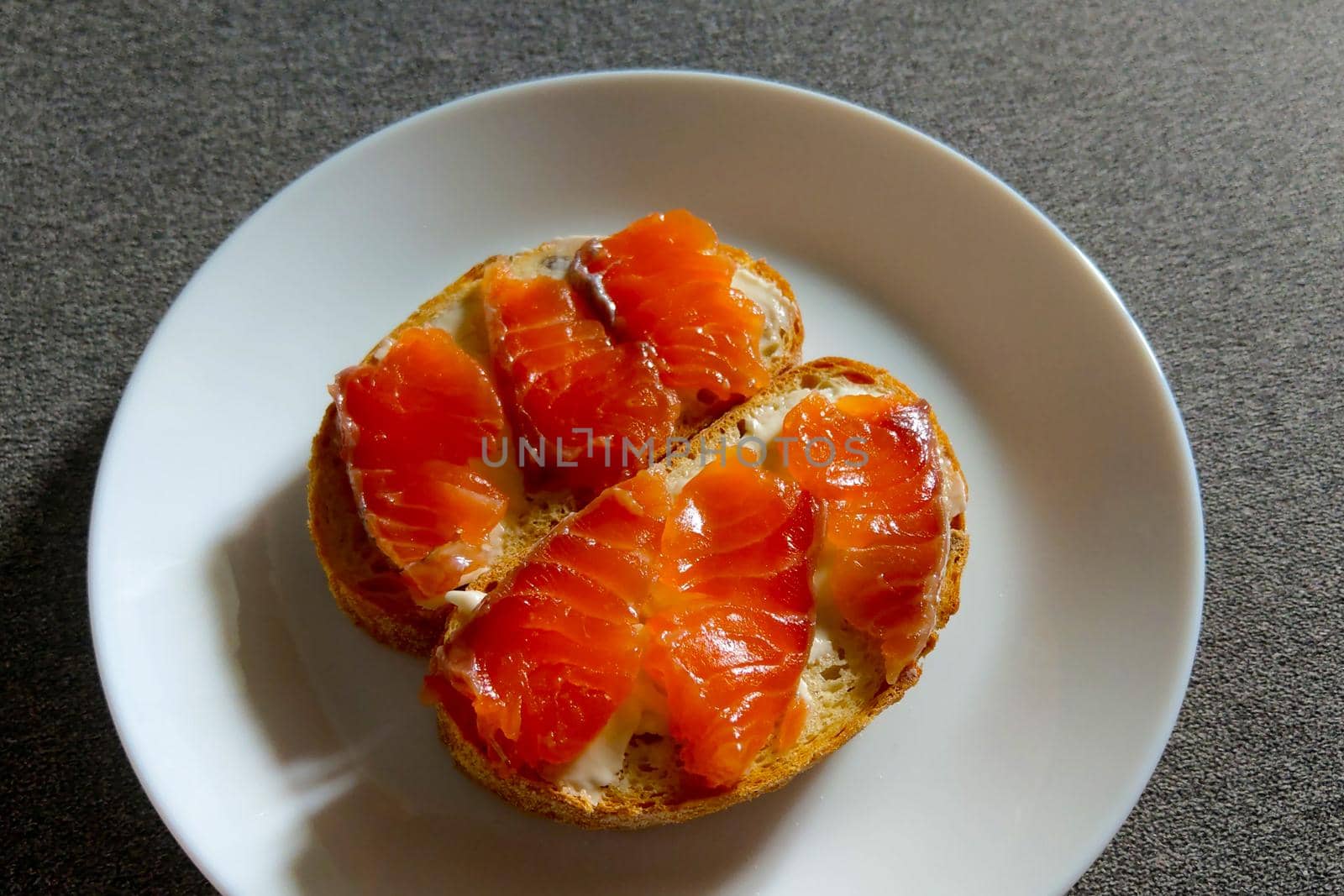 On a plate are small sandwiches of red fish. Healthy light food. A quick snack