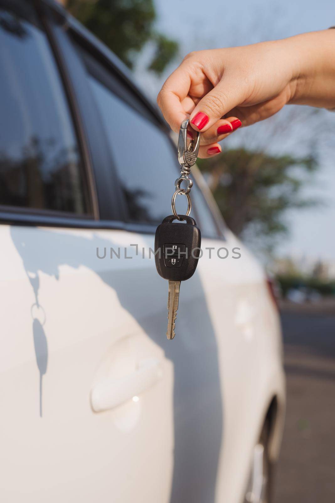 Young woman holding in a hand car keys.