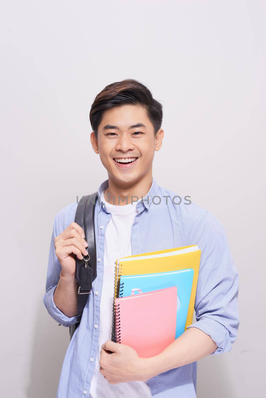 Confident asian handsome student holding books  by makidotvn