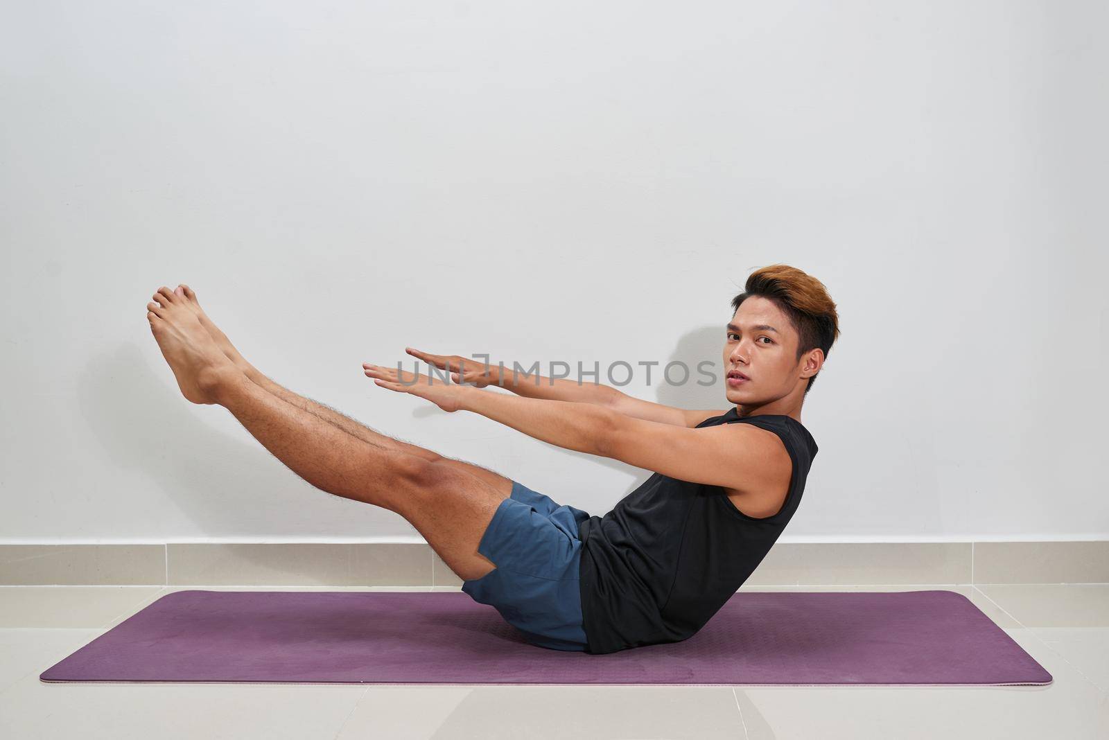Young Man Exercising On Exercise Mat, Indoors