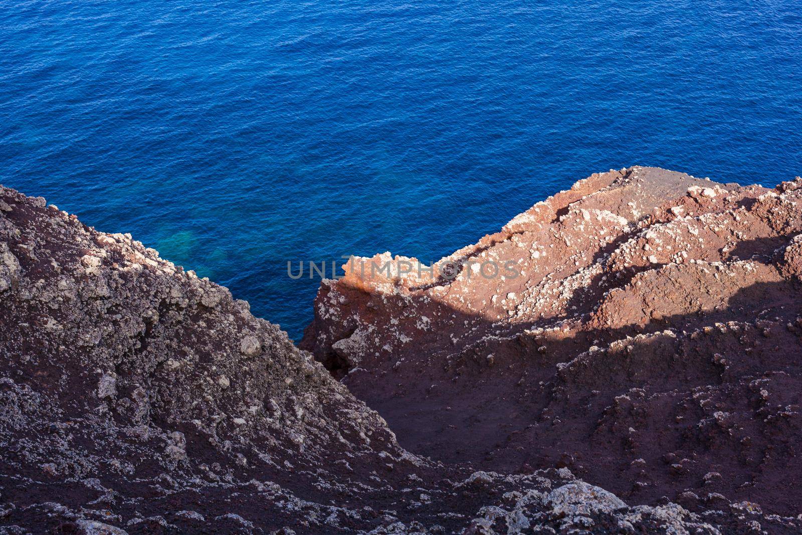 View of the scenic lava rock cliff in the Linosa island. Sicily by bepsimage