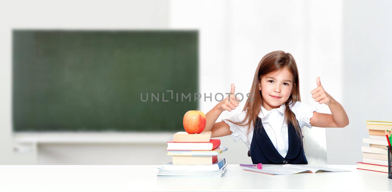 Happy and cute teen school girl showing thumbs up. by Taut