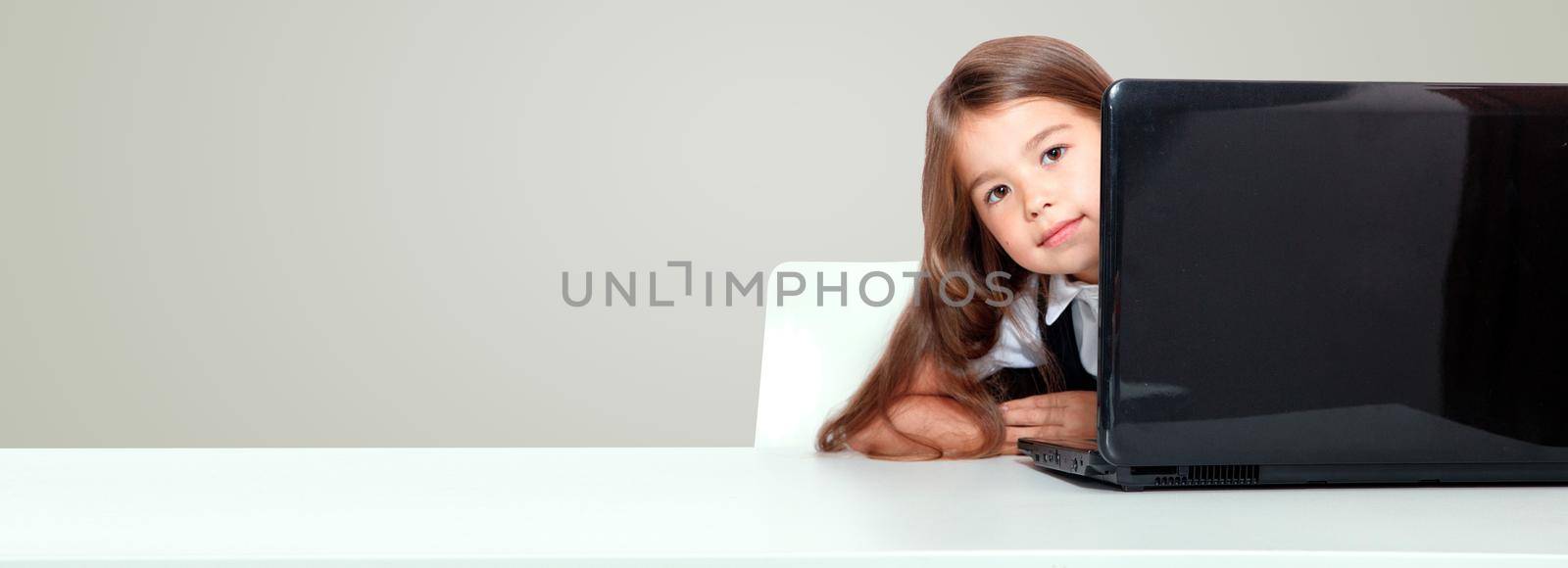 Happy and cute teen school girl sitting on laptop by Taut