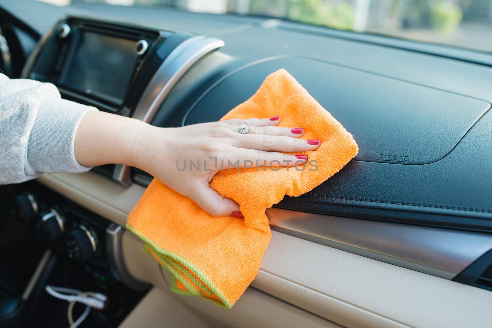 Hand with microfiber cloth cleaning seat, auto detailing and valeting concept, washing car care interior, selective focus by makidotvn