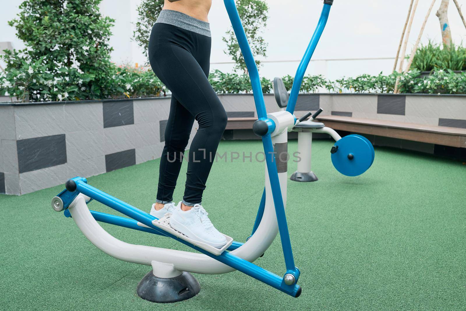 Asian woman exercising at outdoors gym playground equipment