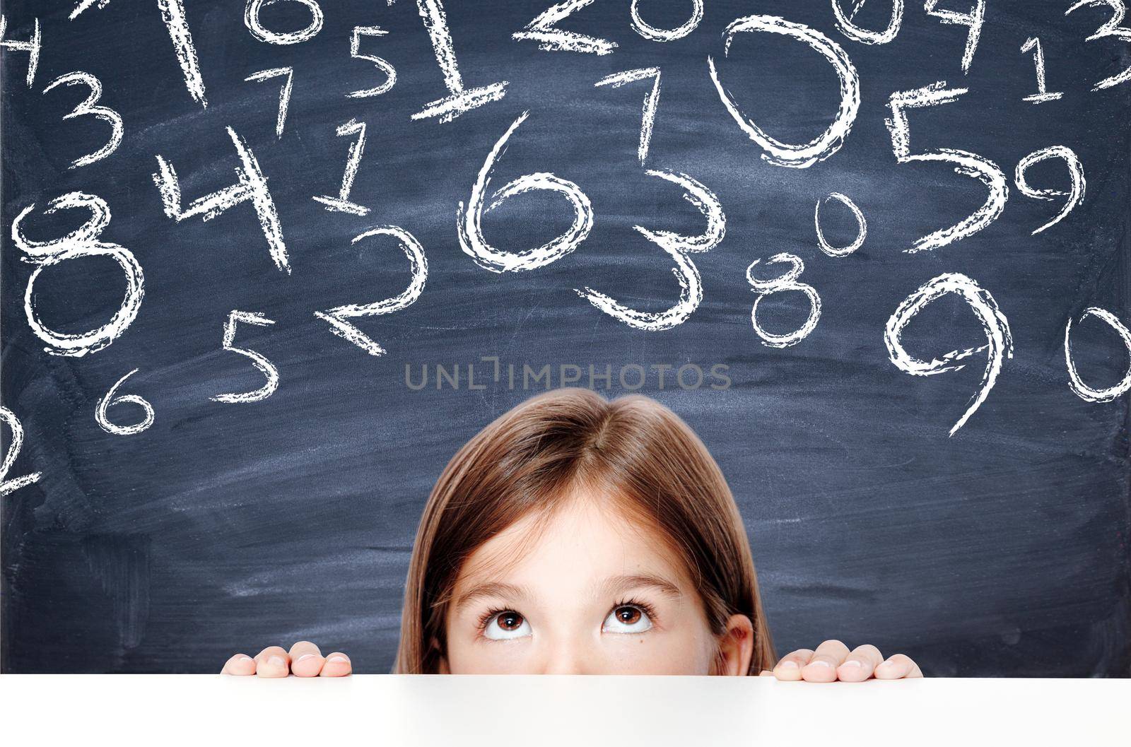 Cute little child girl looking up on the desk at school. by Taut