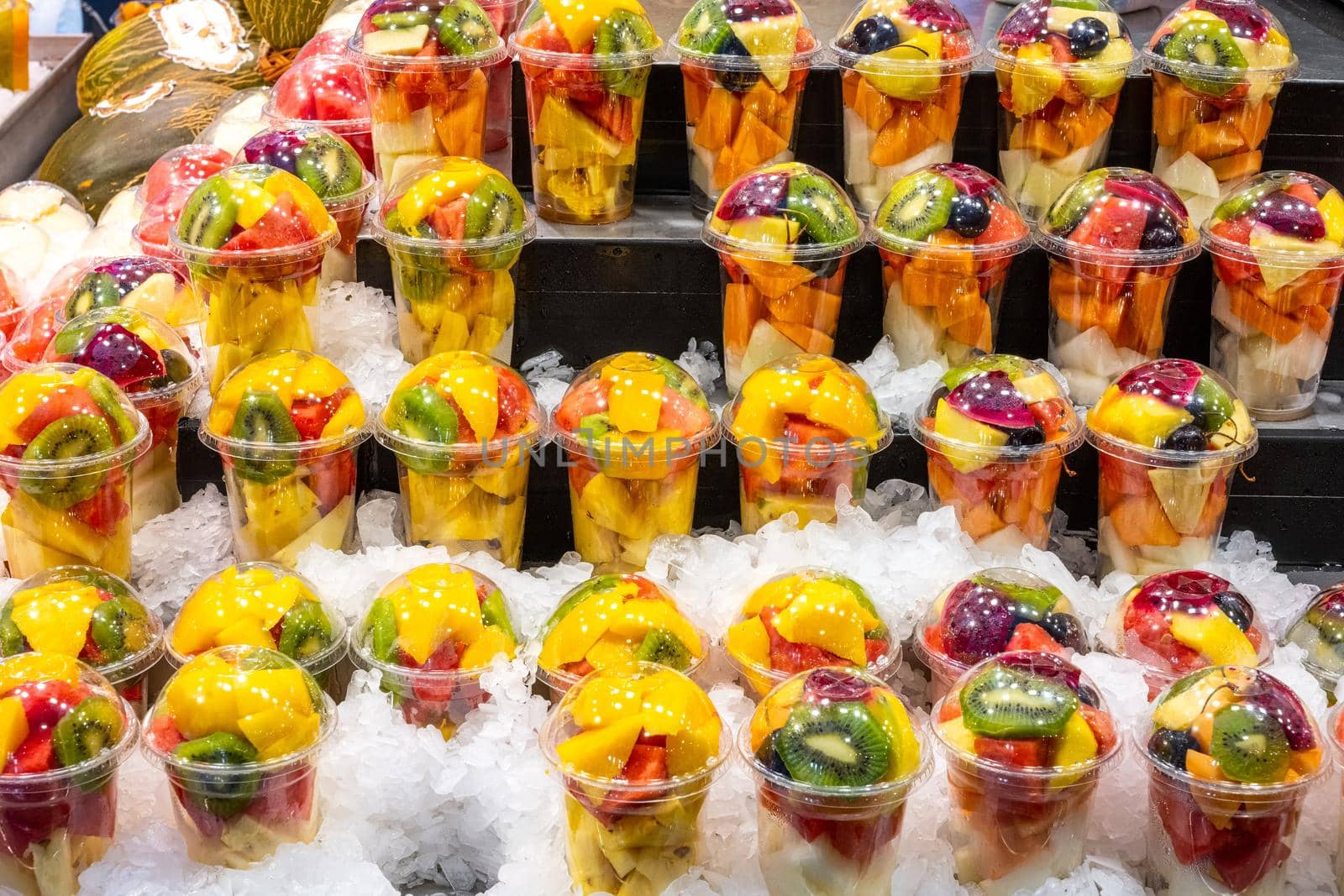 A variety of fruit salads at a market by elxeneize