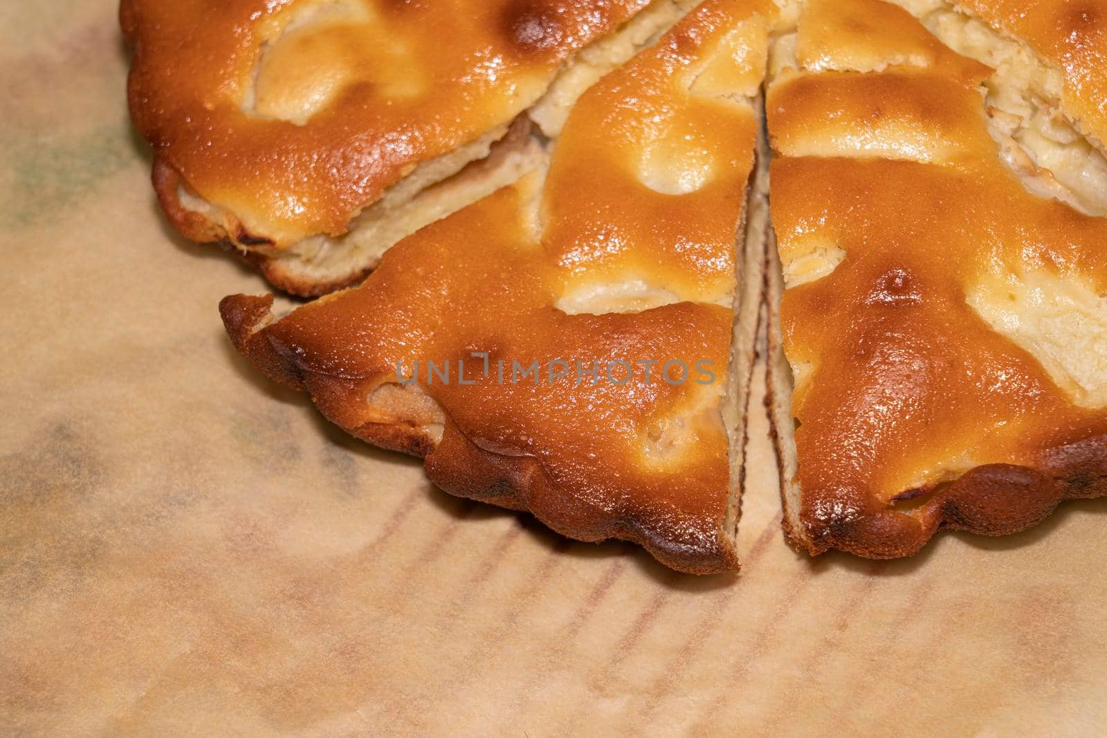 apple pie cut into pieces on paper close-up. High quality photo
