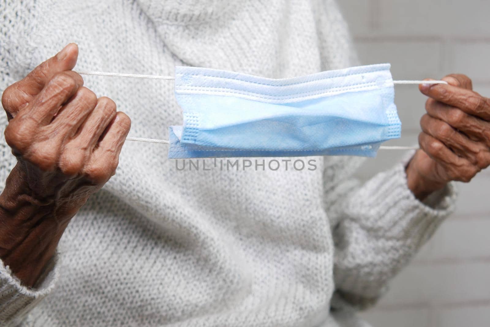 man hand holding surgical face mask, close up .