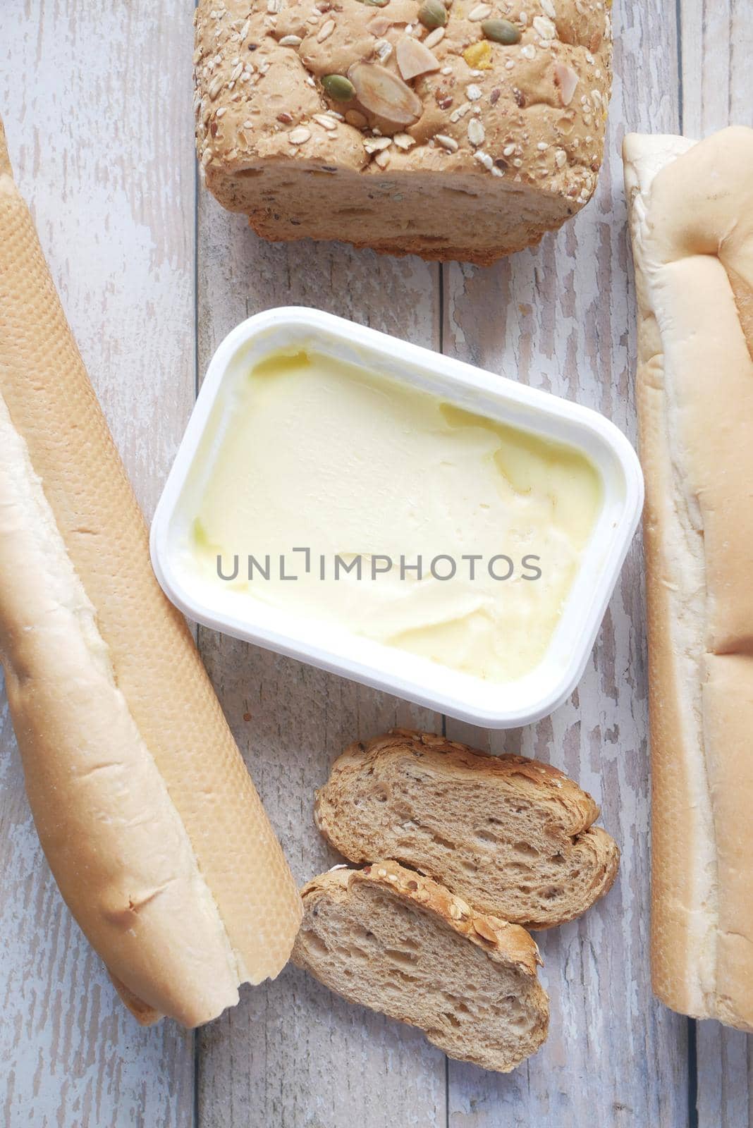slice of butter and whole meal bread on chopping board .