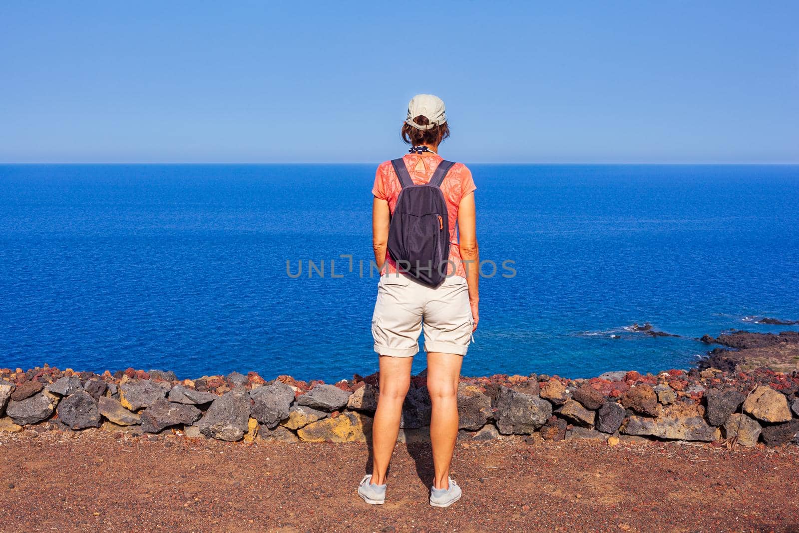 Woman looking the sea from the top of the volcano called Monte Nero, Linosa. Sicily. Italy