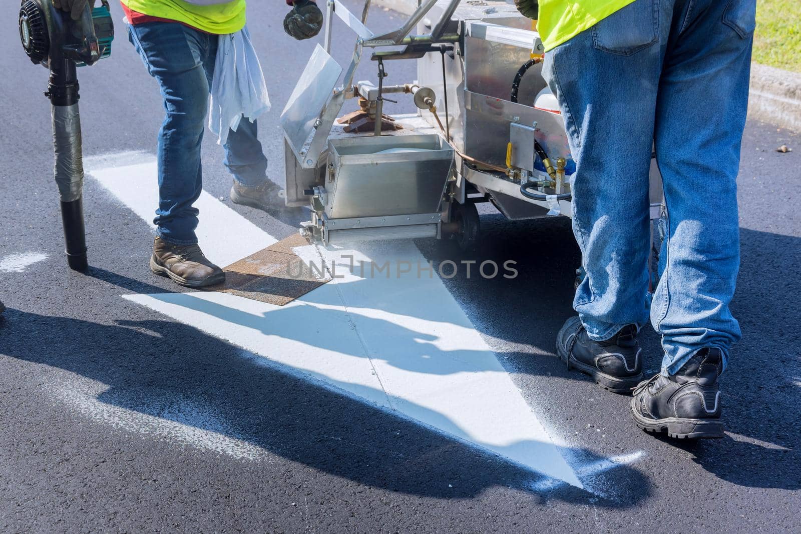 Worker thermoplastic spray marking machine painting work on the street by ungvar