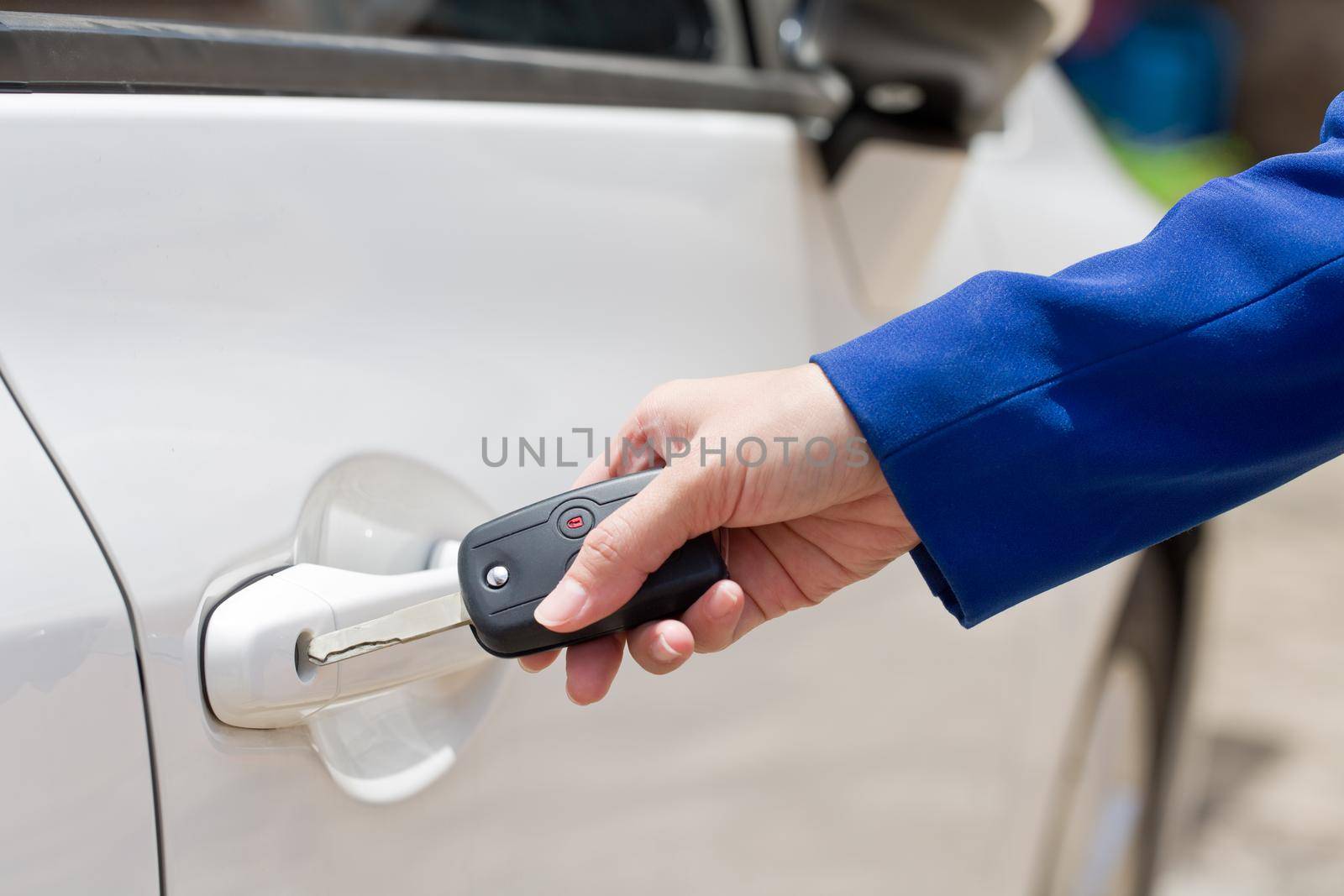 Female hand open the white car on key system automatic.  by jayzynism