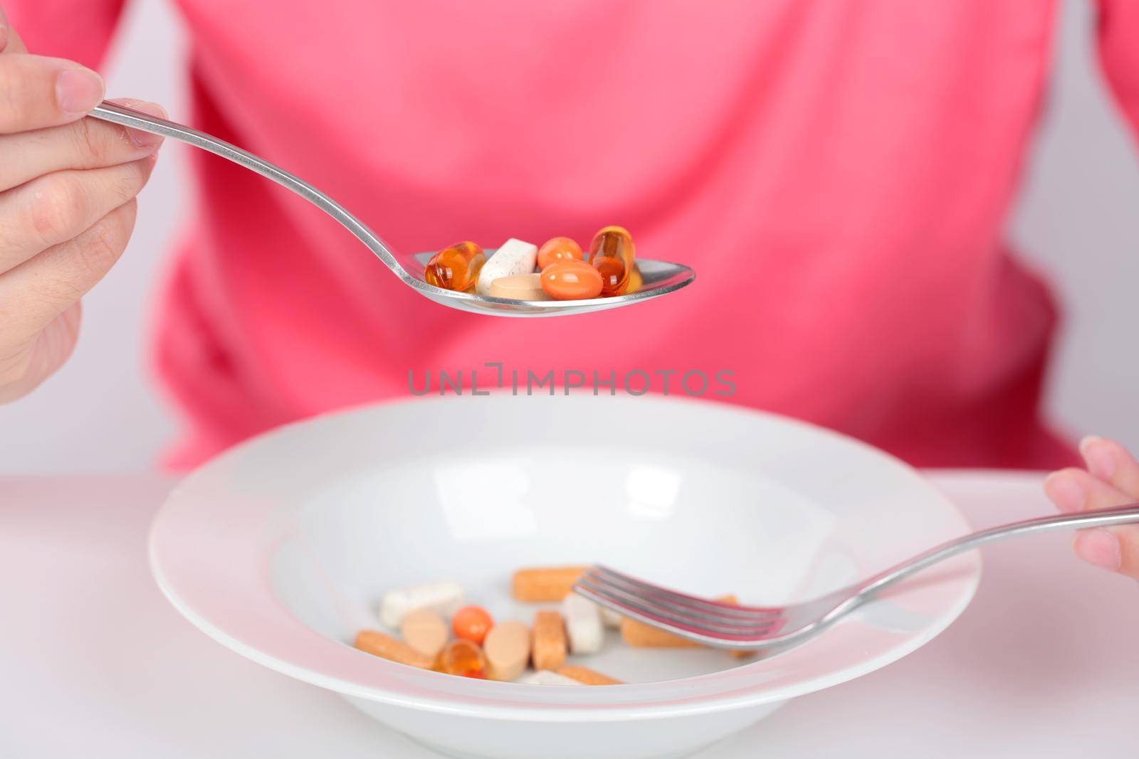 Young women eating medicine capsules on spoon for health.