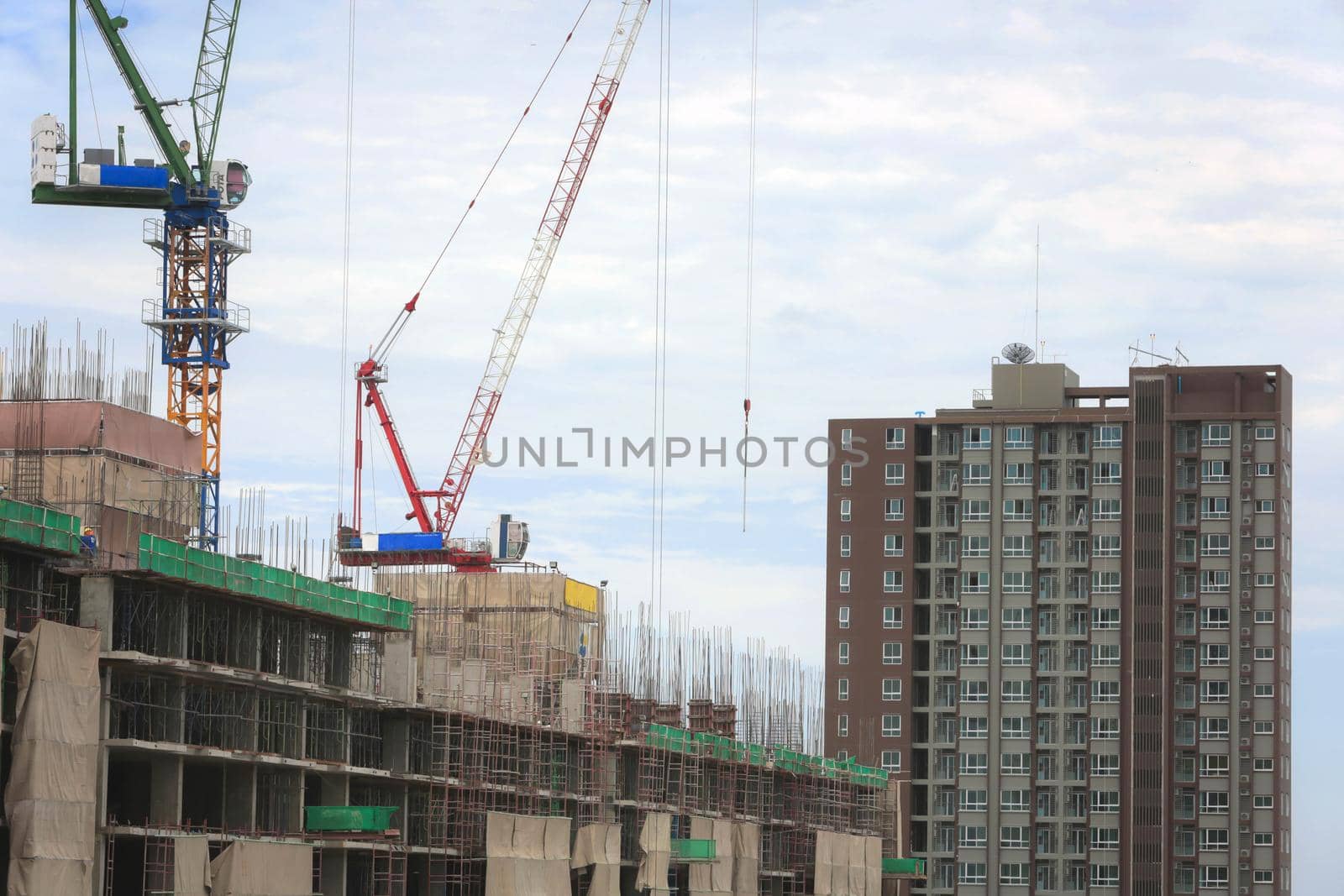 Nakhonratchasima, THAILAND - August 11, 2015 : Crane working building in city on sky. by jayzynism