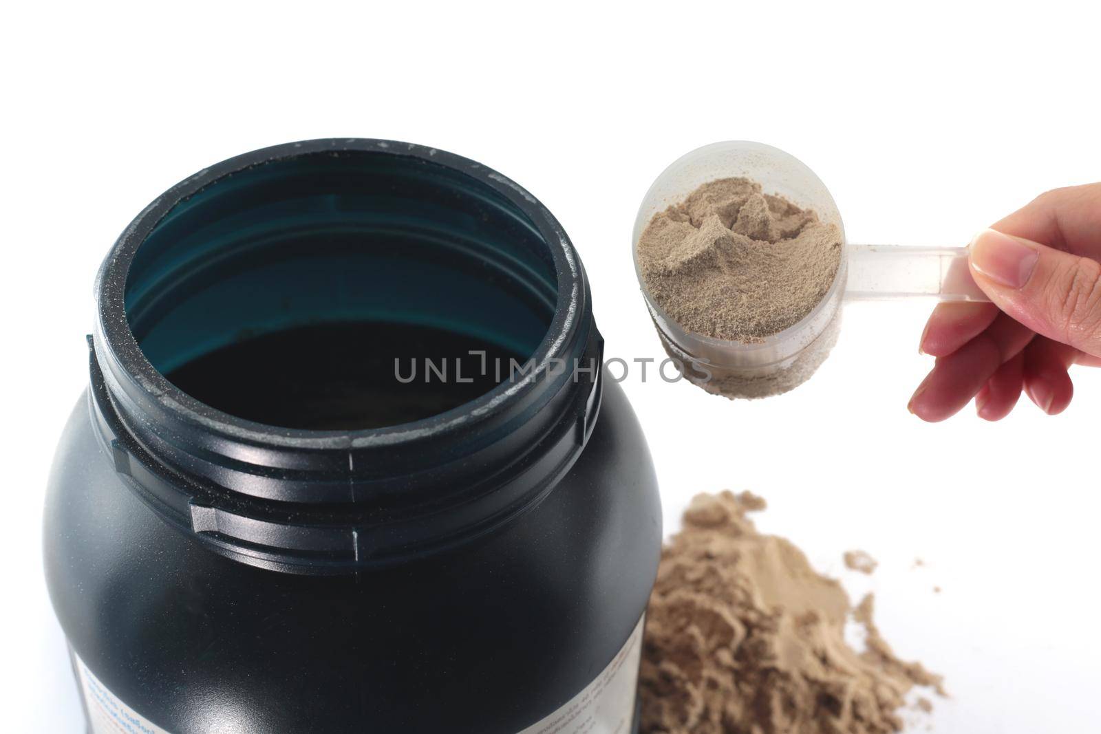 The hand raise a spoon measure Whey protein chocolate powder for fitness and bodybuilding gaining muscle.