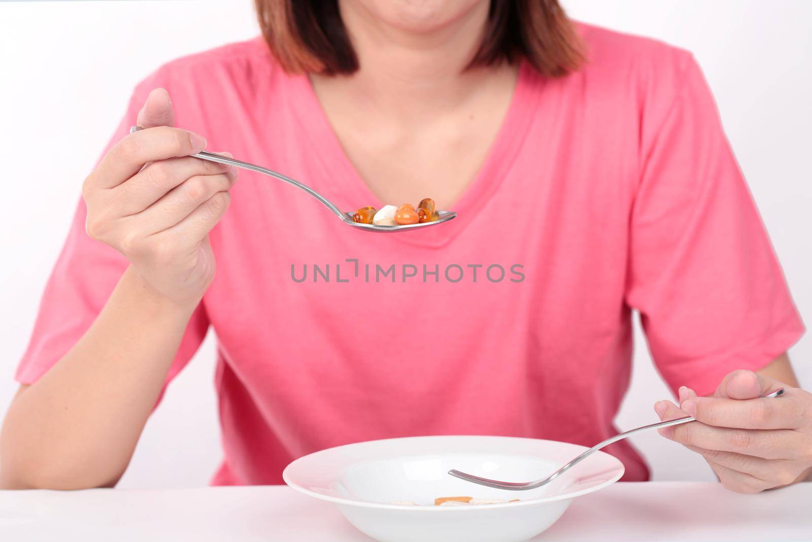 Young women eating medicine capsules on spoon for health.