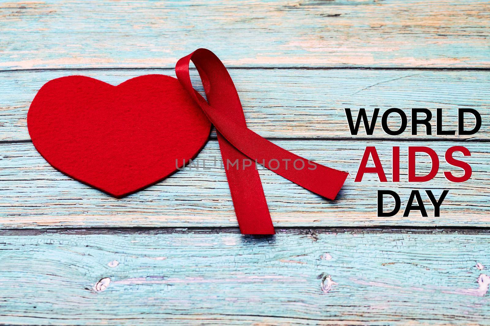 World Aids Day, Awareness Sign Red Ribbon, the fight against AIDS sign on the blue wooden background by psodaz