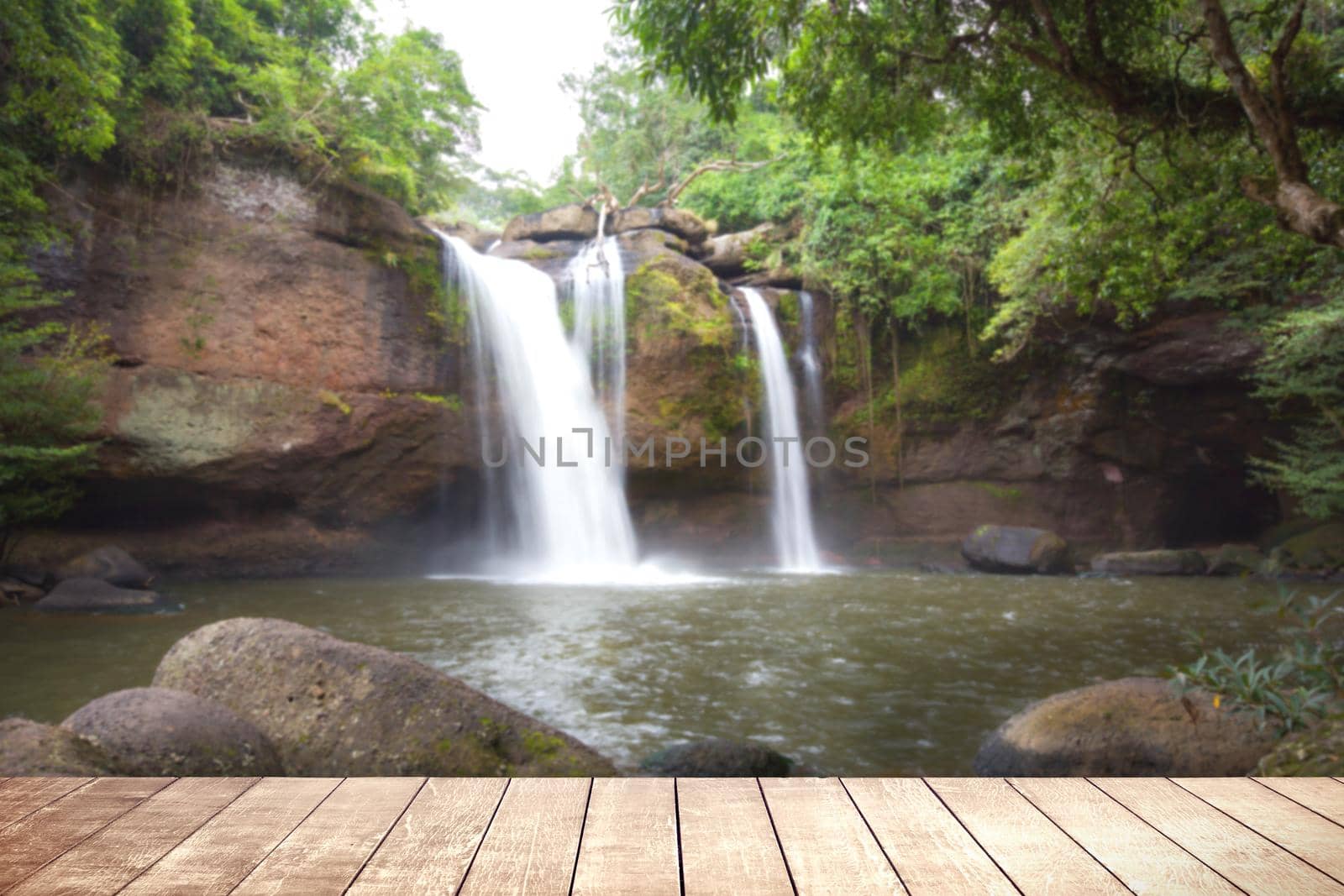 Wooden table with environmental in water fall  forest. by jayzynism