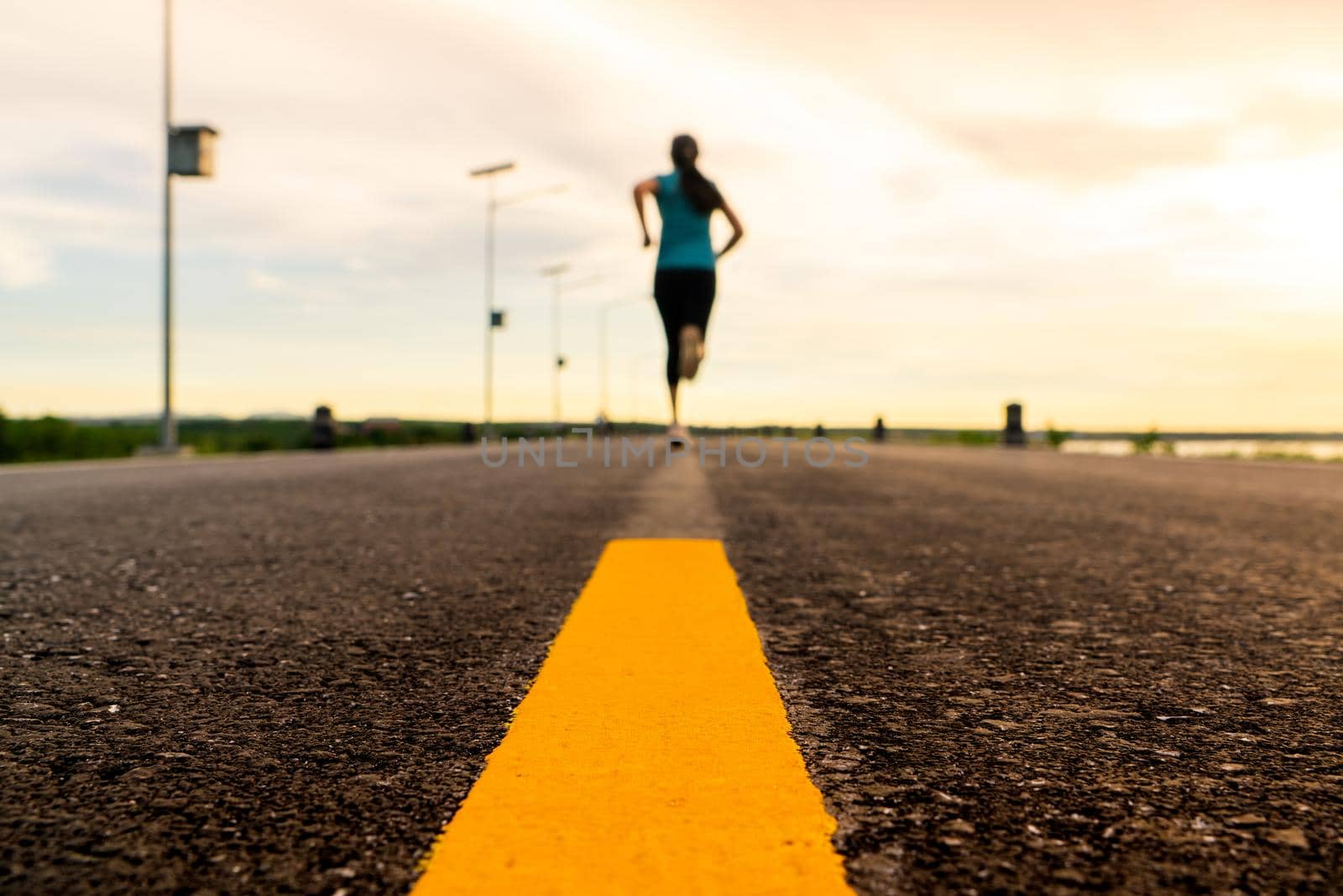 Athlete running on the road trail in sunset training for marathon and fitness. motion blur of woman exercising outdoors