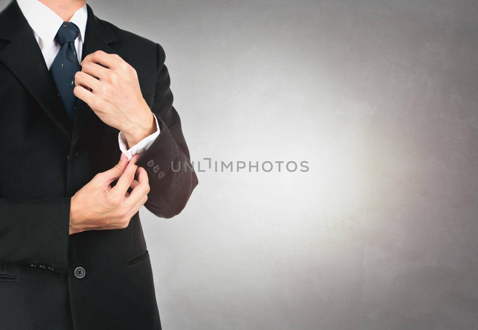 Businessman button up in suit on concrete background texture. by jayzynism