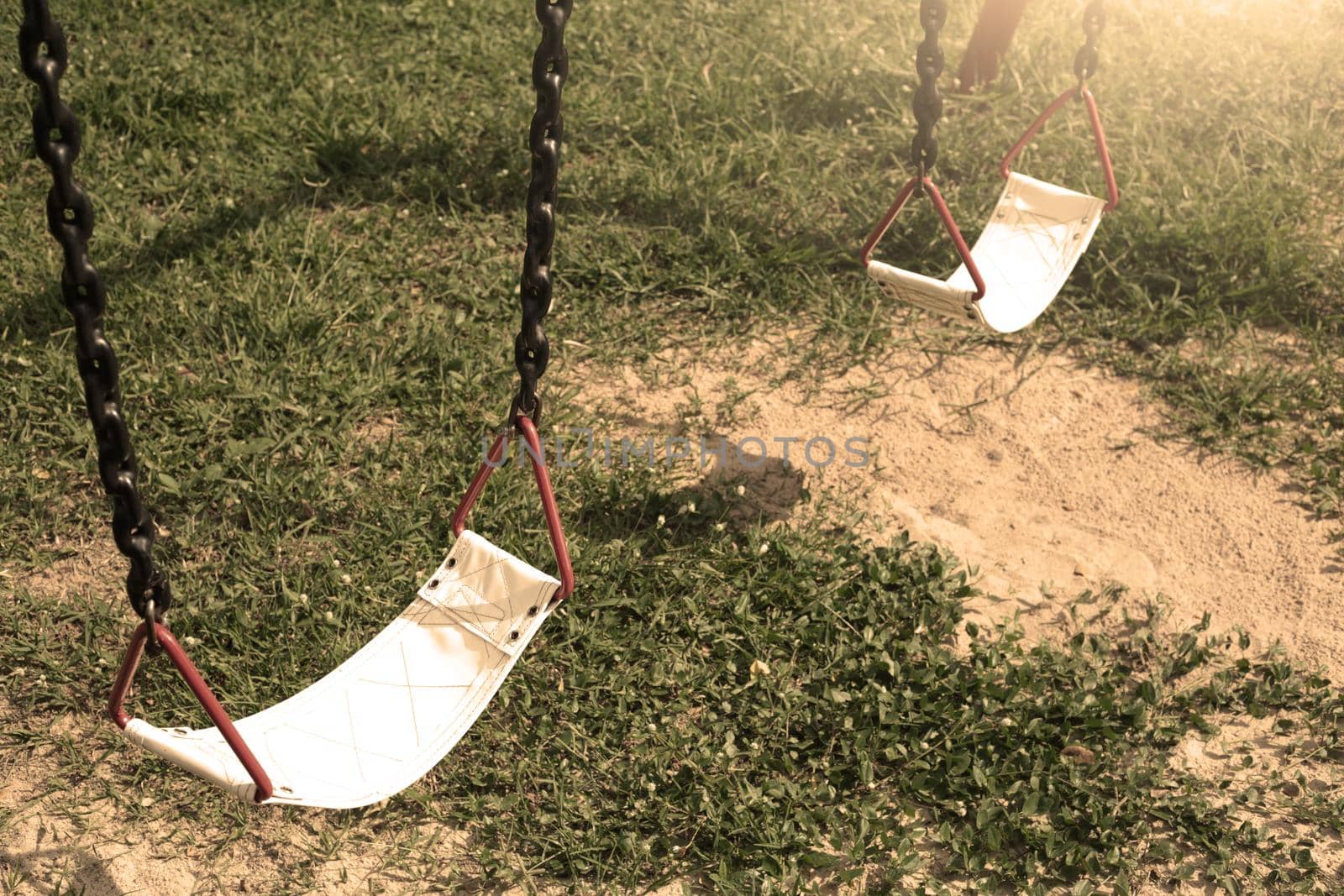 Playground swing lonely in the park and garden. by jayzynism