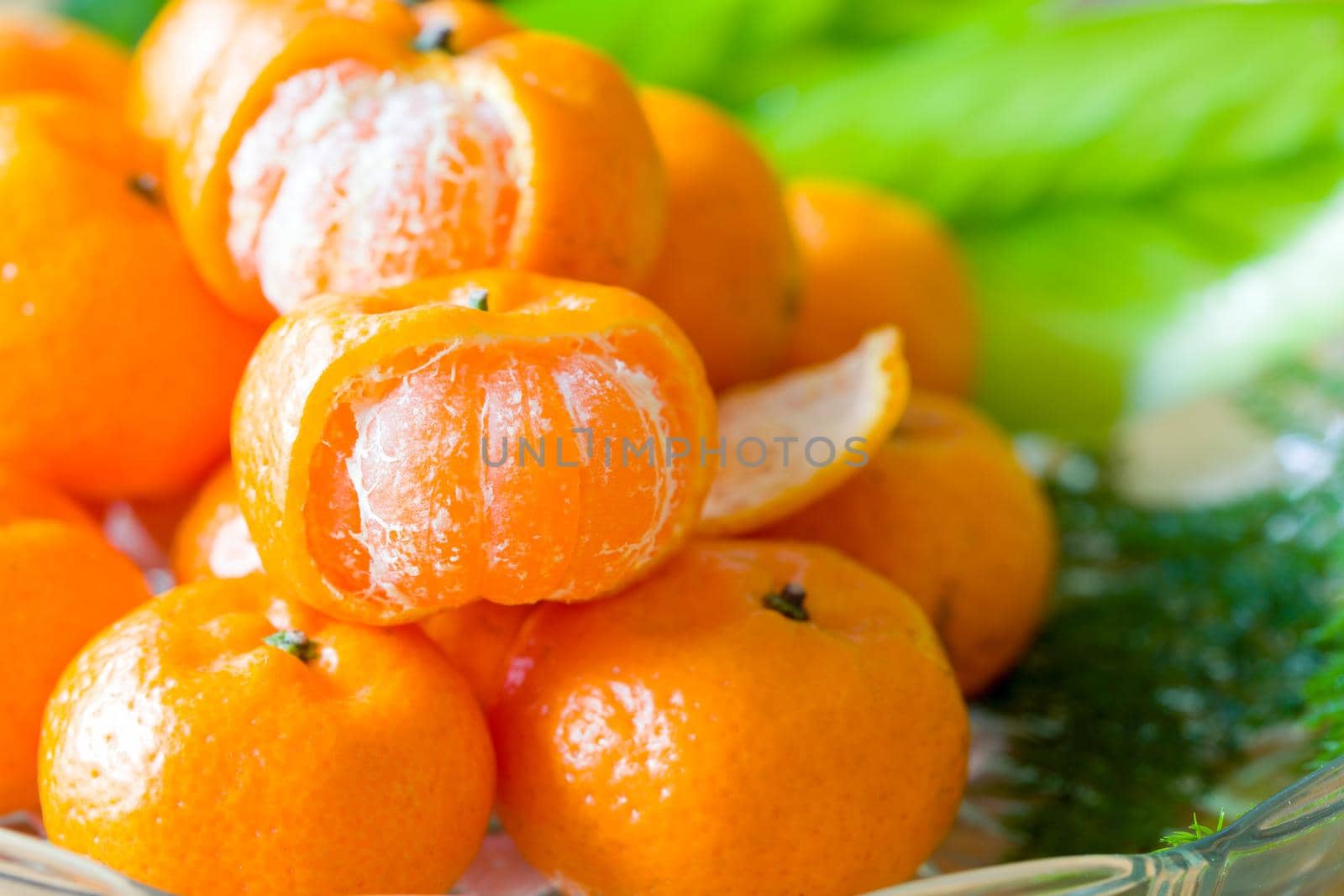 Close up orange on dish glass with green leaf. by jayzynism