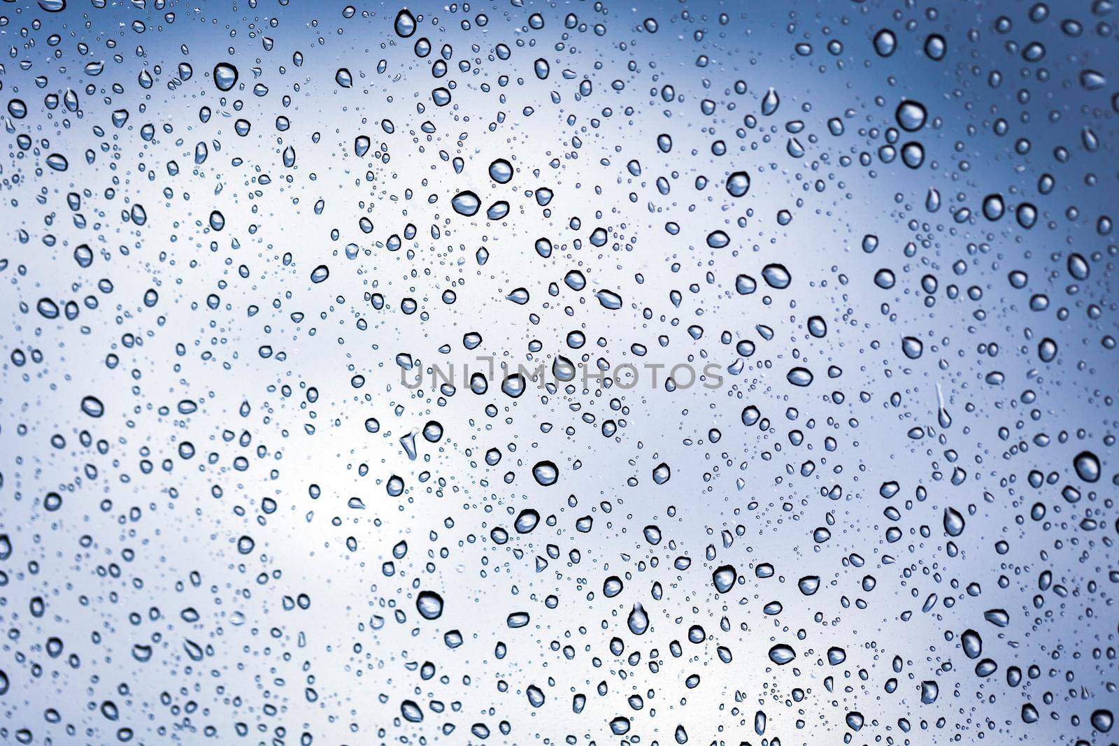 Rainy water drop on glass mirror background. by jayzynism