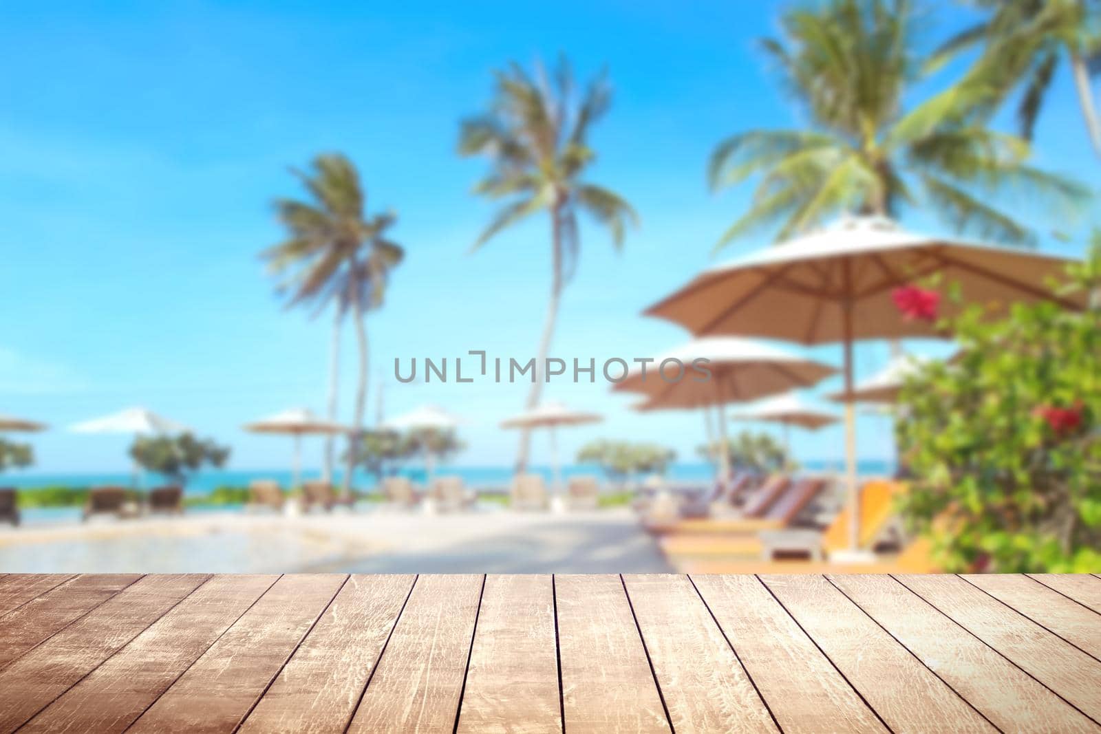 Wooden table with blurry tropical sea and resort background.