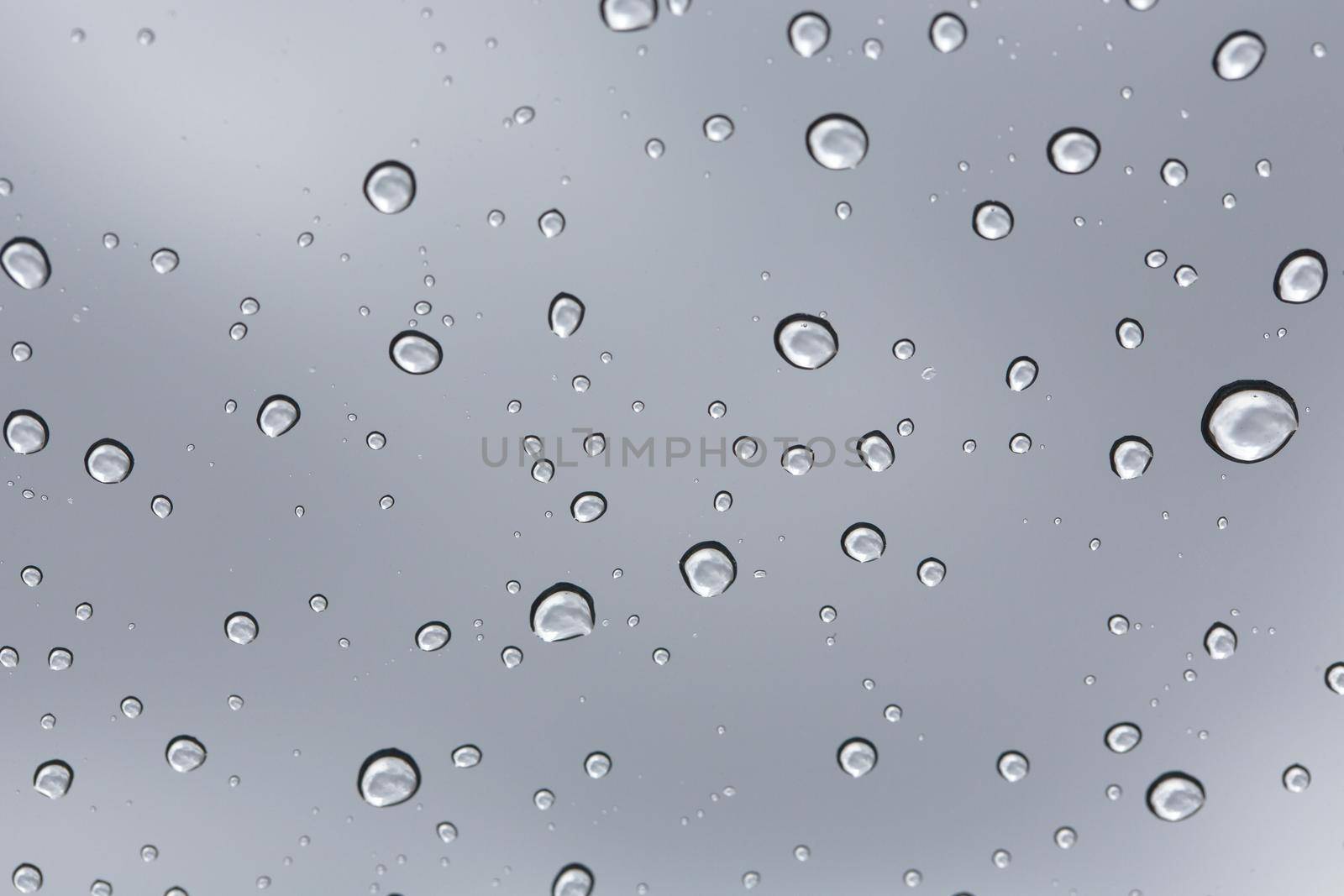 Rainy water drop on glass mirror background.