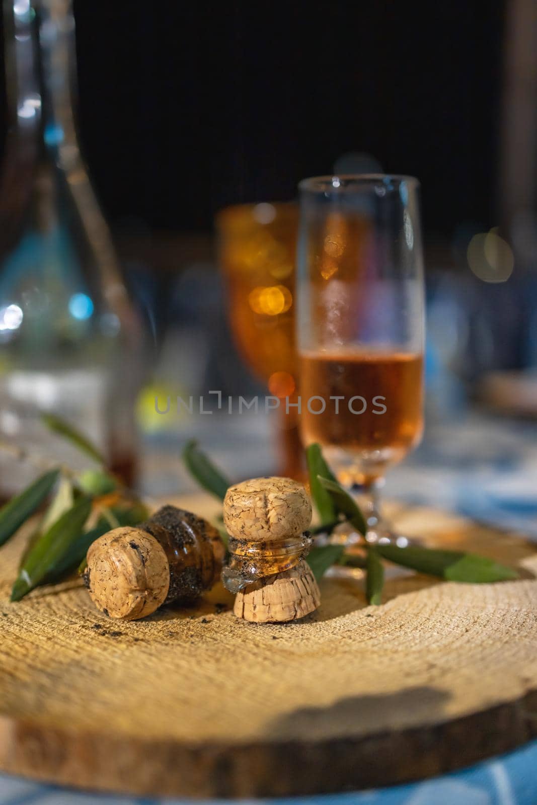 Glass of champagne with two broken corks lay on wooden board on table