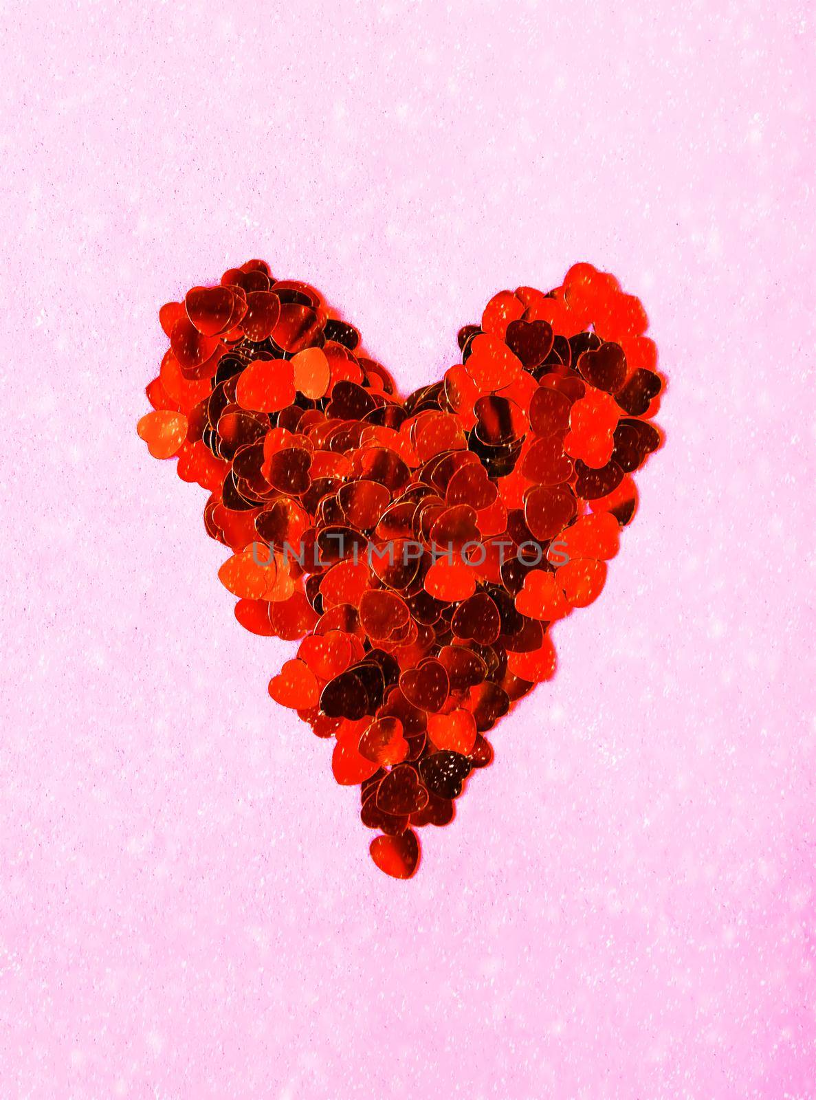 Valentine's day decorative background with heart made of tinsel. Snowfall effect on soft pink background.