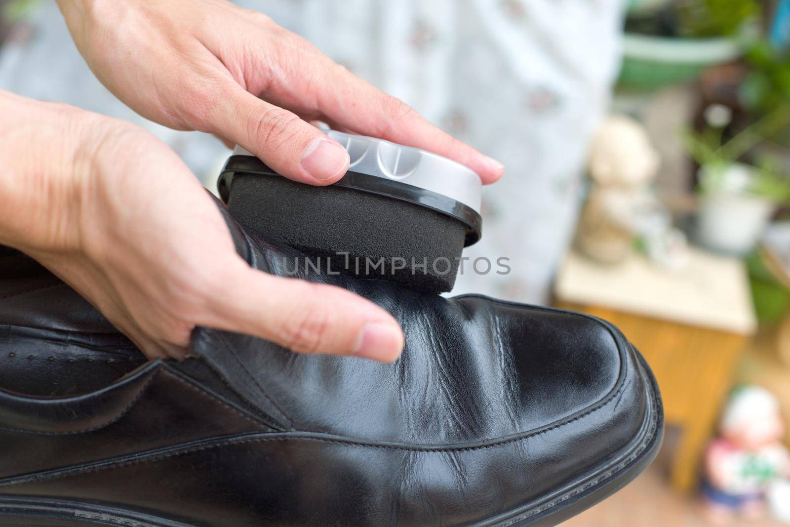 Hands polish leather black shoes.