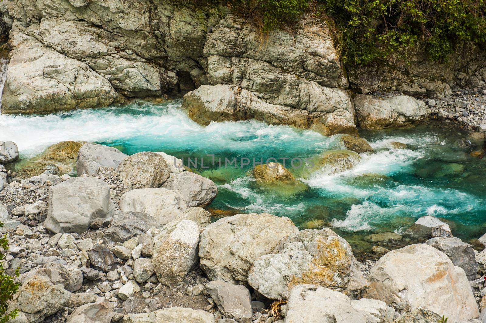 Blue flowing water of the river in the New Zealand by fyletto