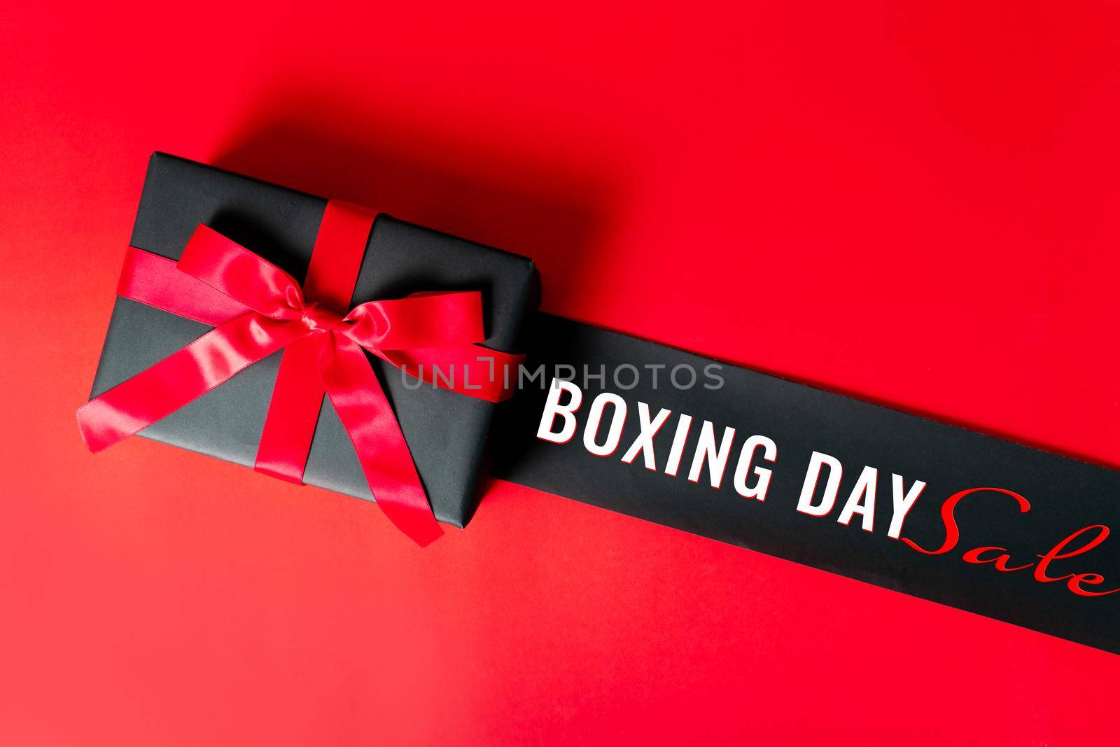 Boxing day Sale concept Christmas gift box on red background, top view by psodaz