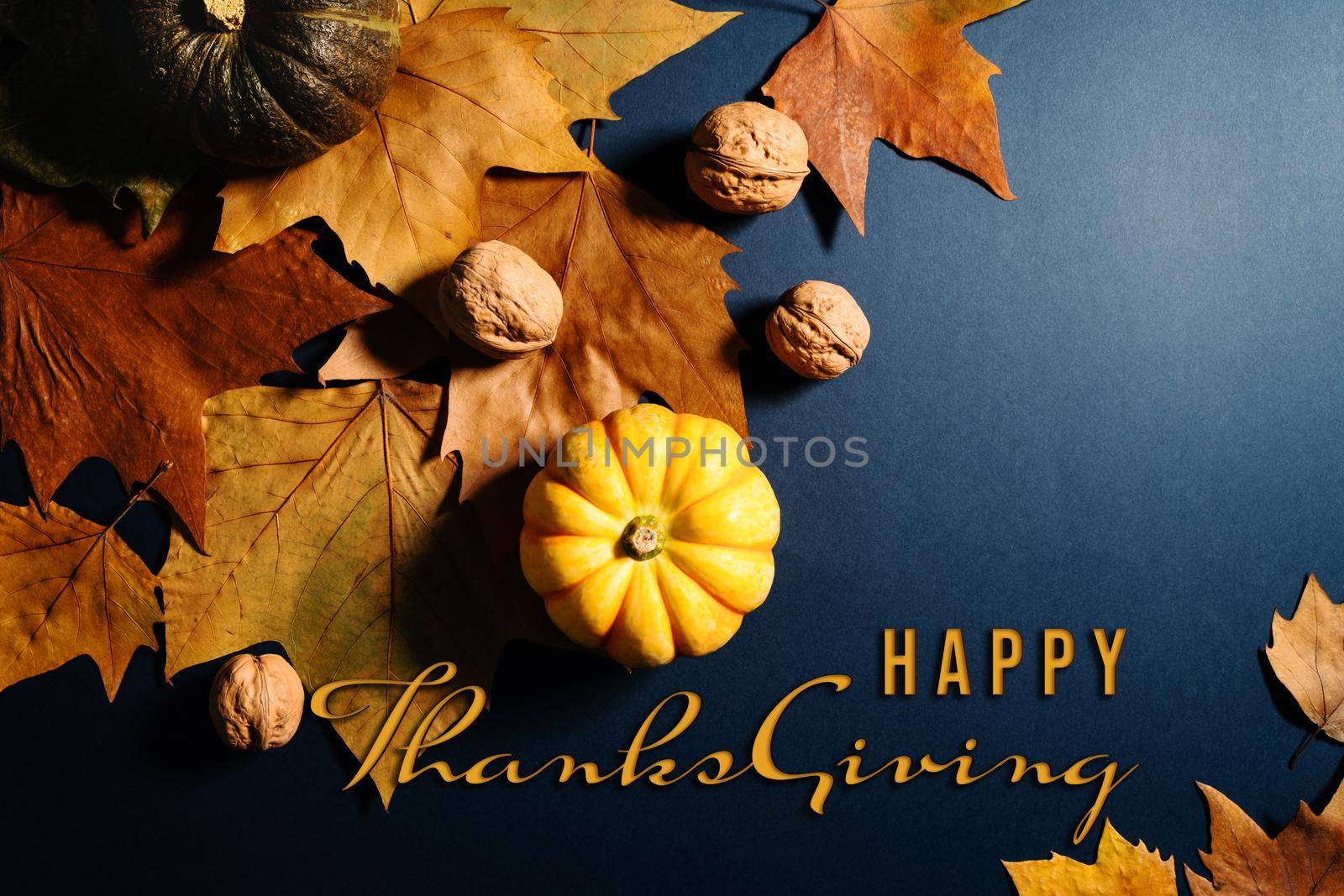 Happy Thanksgiving Day with maple leaves, nut and pumpkin on blue background by psodaz